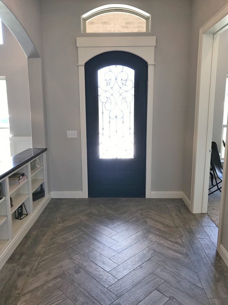 ダラスにある高級な広いカントリー風のおしゃれな玄関ドア (グレーの壁、磁器タイルの床、黒いドア、マルチカラーの床) の写真