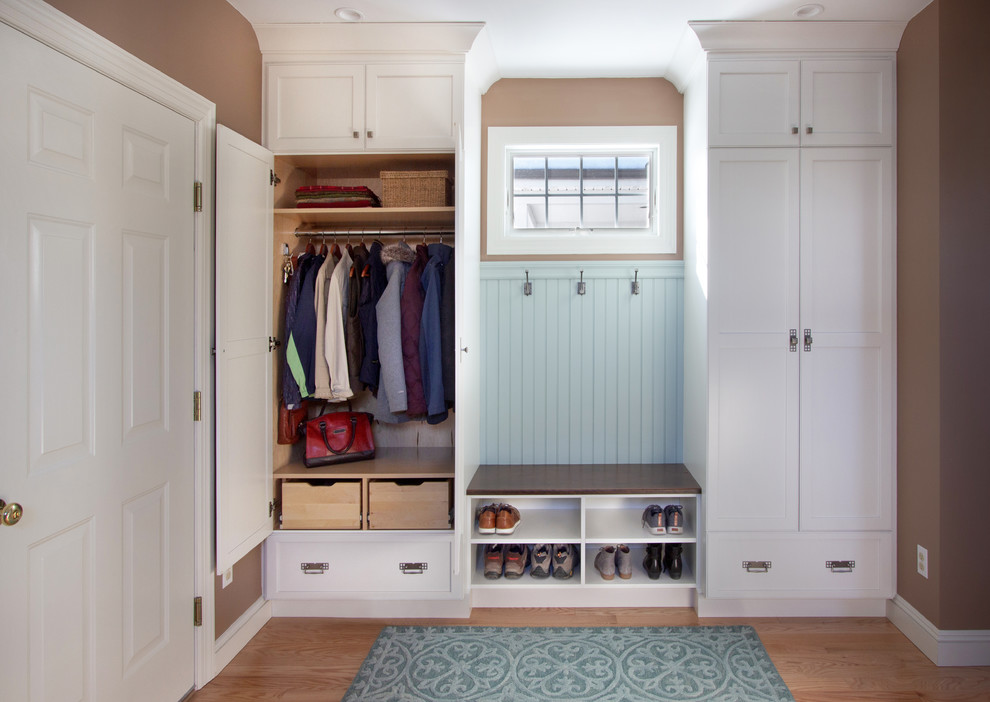 Mid-sized transitional medium tone wood floor mudroom photo in New York with brown walls