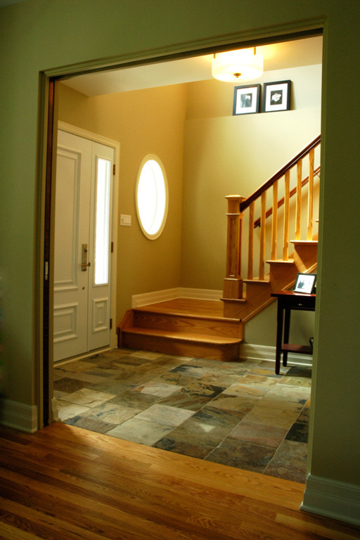 Inspiration pour un hall d'entrée craftsman de taille moyenne avec un mur vert, un sol en ardoise, une porte simple et une porte blanche.