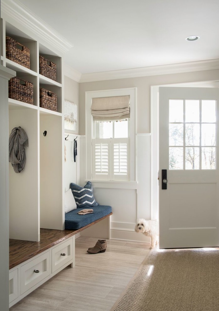 Imagen de vestíbulo posterior tradicional de tamaño medio con paredes beige, puerta simple, puerta blanca, suelo beige y suelo de madera clara