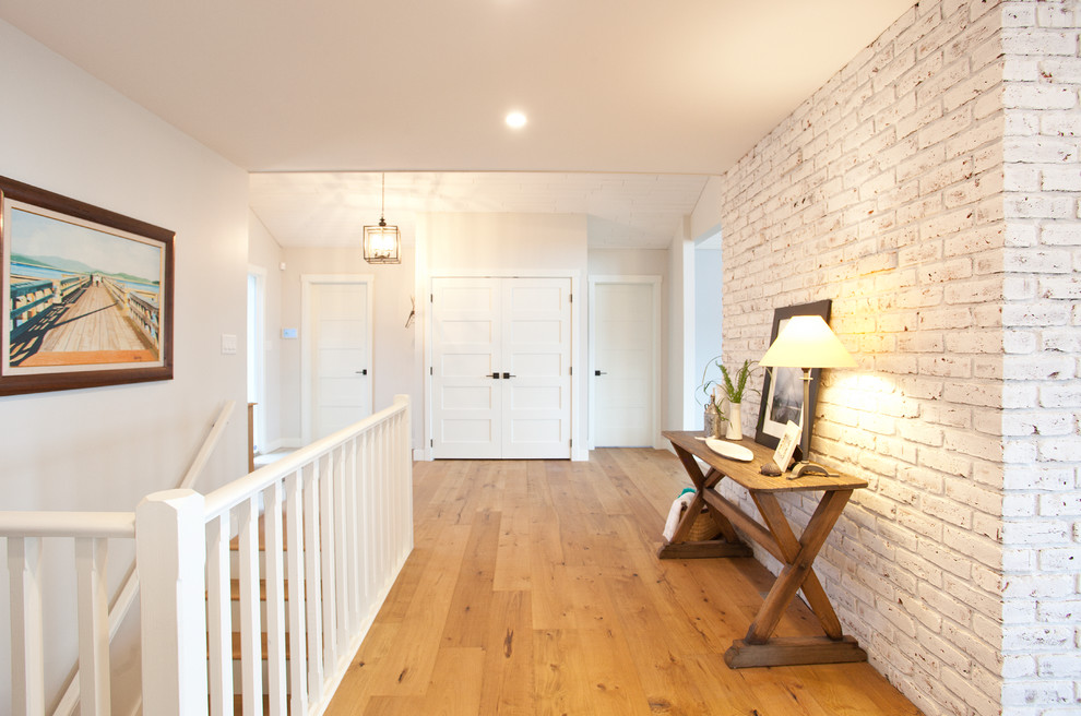 Diseño de hall tradicional renovado de tamaño medio con paredes grises, suelo de madera clara, puerta simple y puerta de madera en tonos medios