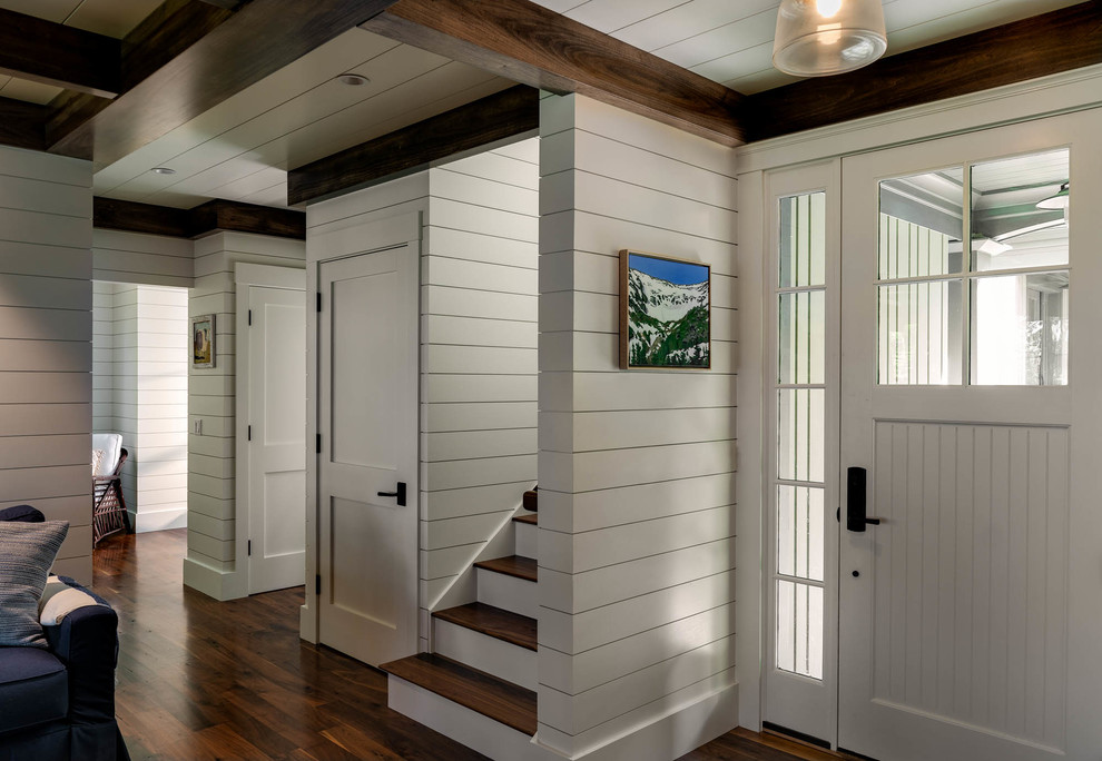 Foto di una porta d'ingresso american style con pareti bianche, parquet scuro, una porta singola, una porta bianca e pavimento marrone