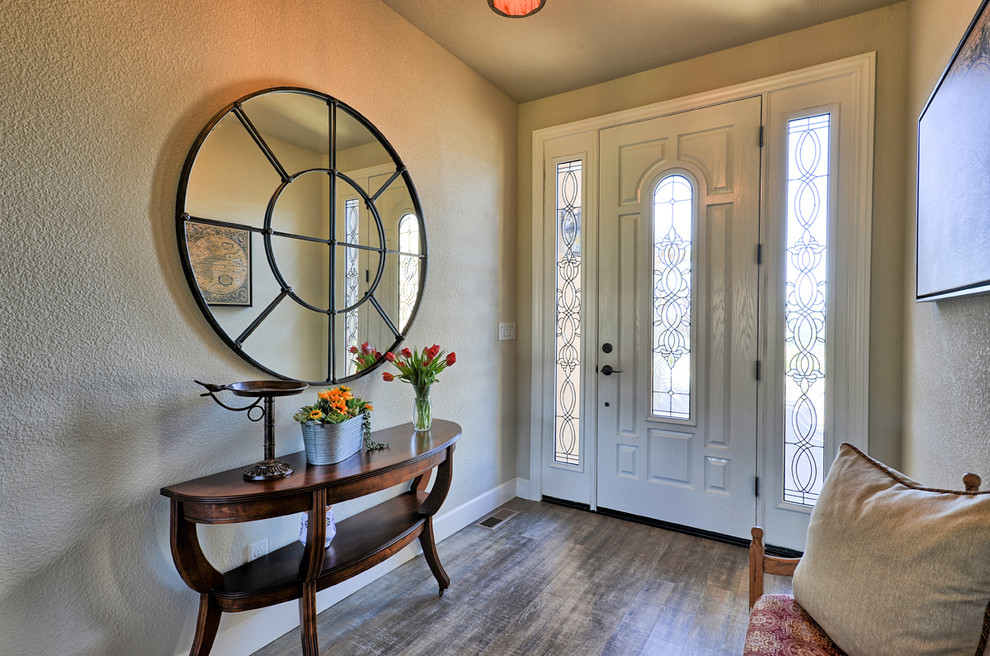 Foto de distribuidor clásico renovado de tamaño medio con paredes beige, suelo laminado, puerta simple, puerta blanca y suelo gris