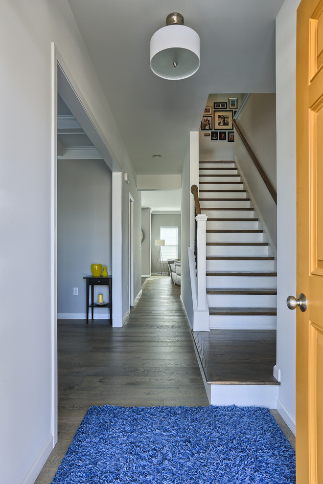Idées déco pour une porte d'entrée moderne de taille moyenne avec un mur gris, un sol en bois brun et une porte jaune.