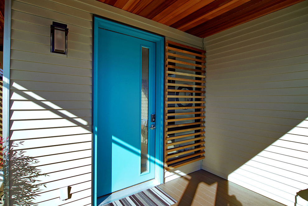 Стильный дизайн: входная дверь в современном стиле с белыми стенами, одностворчатой входной дверью, синей входной дверью и деревянным полом - последний тренд