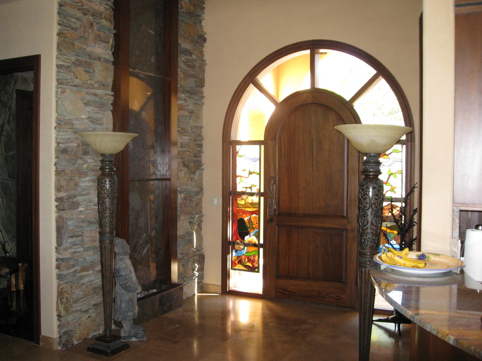 Aménagement d'une porte d'entrée méditerranéenne de taille moyenne avec un mur beige, une porte simple et une porte en bois foncé.