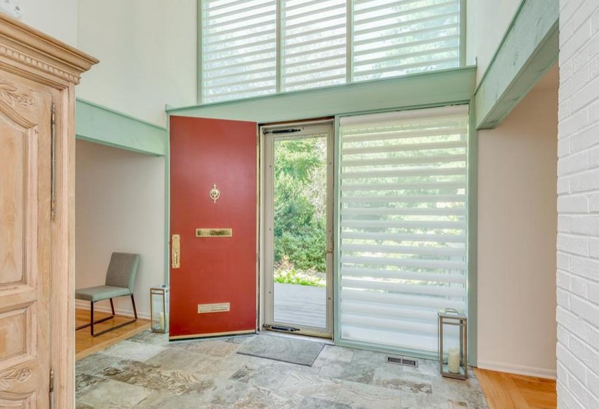 Immagine di una porta d'ingresso industriale di medie dimensioni con pareti bianche, pavimento in gres porcellanato, una porta singola, una porta blu e pavimento multicolore