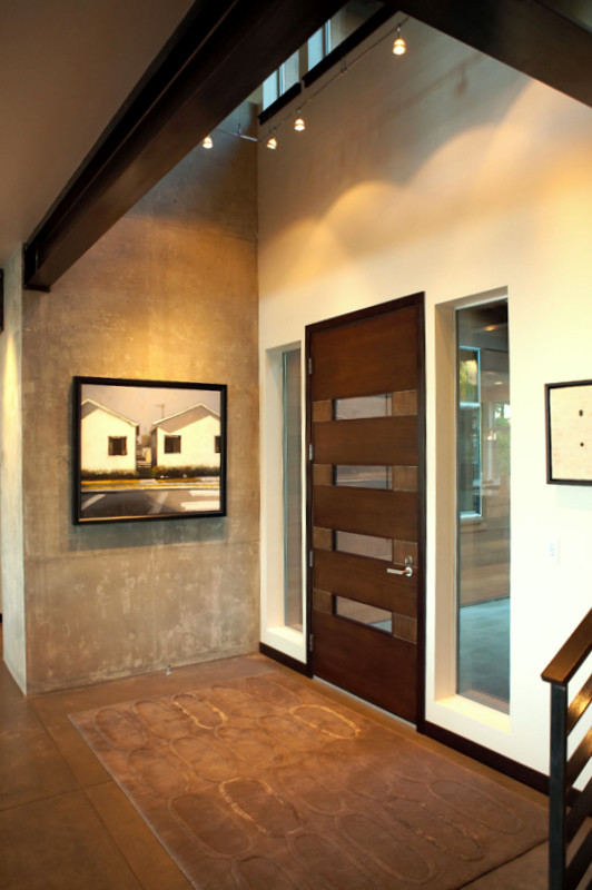 Foto på en mellanstor funkis ingång och ytterdörr, med grå väggar, betonggolv, en enkeldörr, en brun dörr och beiget golv