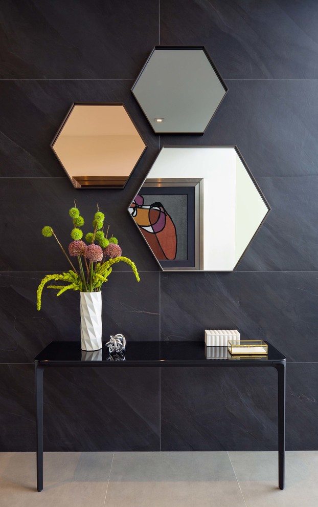 Diseño de distribuidor actual con paredes negras, suelo de baldosas de porcelana, puerta simple, puerta de madera en tonos medios y suelo gris