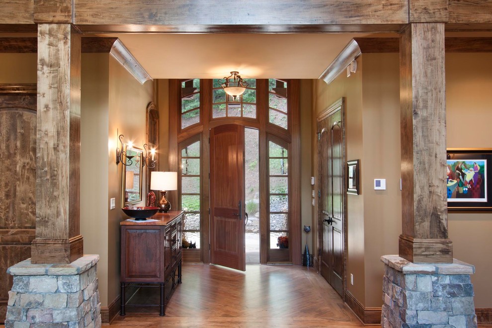Geräumiges Rustikales Foyer mit brauner Wandfarbe, braunem Holzboden, Einzeltür, brauner Haustür und braunem Boden in Sonstige