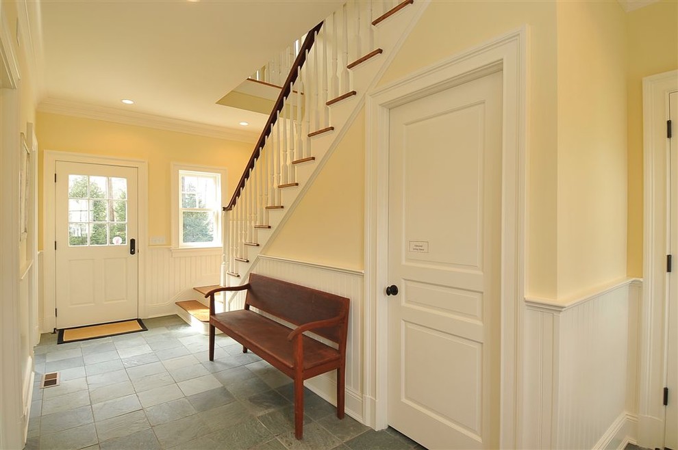 Entryway - mid-sized traditional slate floor entryway idea in New York with yellow walls and a white front door