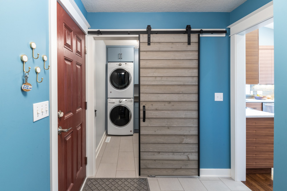 Idéer för en liten modern ingång och ytterdörr, med blå väggar, klinkergolv i porslin, en enkeldörr, mellanmörk trädörr och grått golv