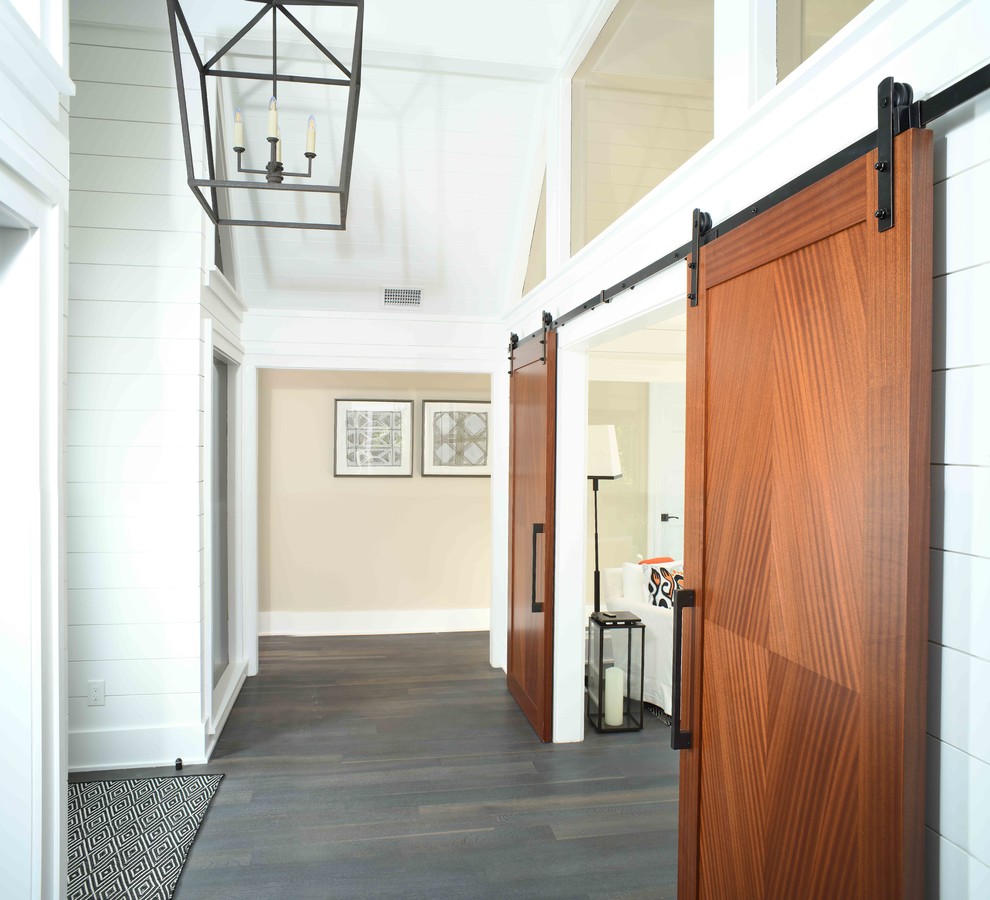 チャールストンにある小さなインダストリアルスタイルのおしゃれな玄関ロビー (白い壁、濃色無垢フローリング、木目調のドア) の写真