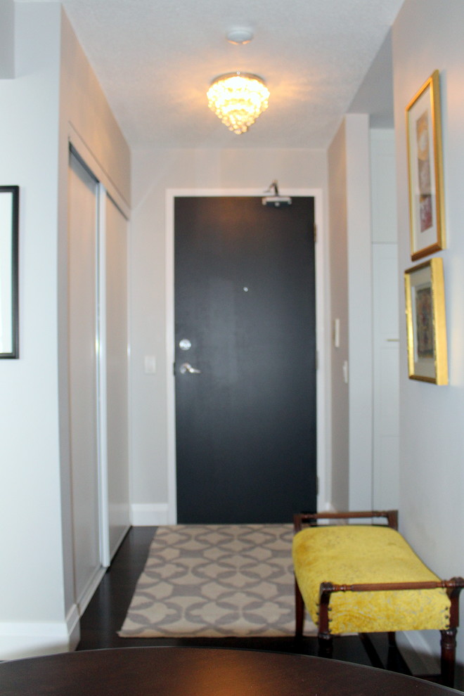 トロントにある低価格の小さなトランジショナルスタイルのおしゃれな玄関ロビー (グレーの壁、濃色無垢フローリング、黒いドア) の写真