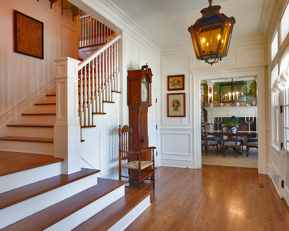 Klassisches Foyer mit braunem Holzboden und Haustür aus Glas in New York