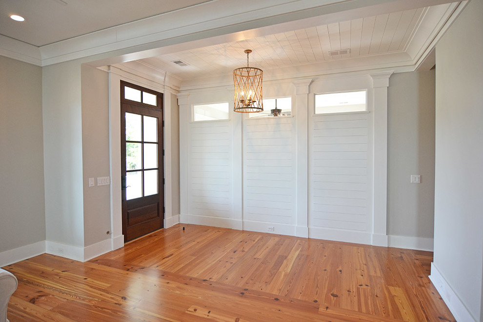 Foto de distribuidor marinero con paredes grises, suelo de madera en tonos medios, puerta simple y puerta de madera en tonos medios