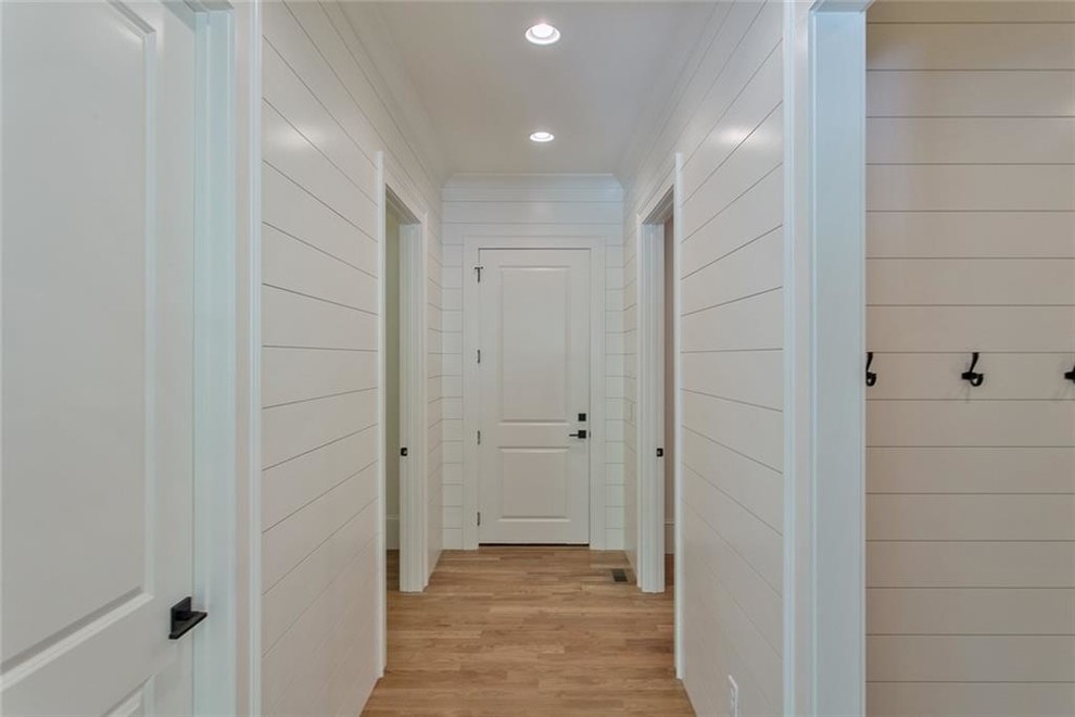Example of a mid-sized light wood floor and gray floor mudroom design in Atlanta with white walls
