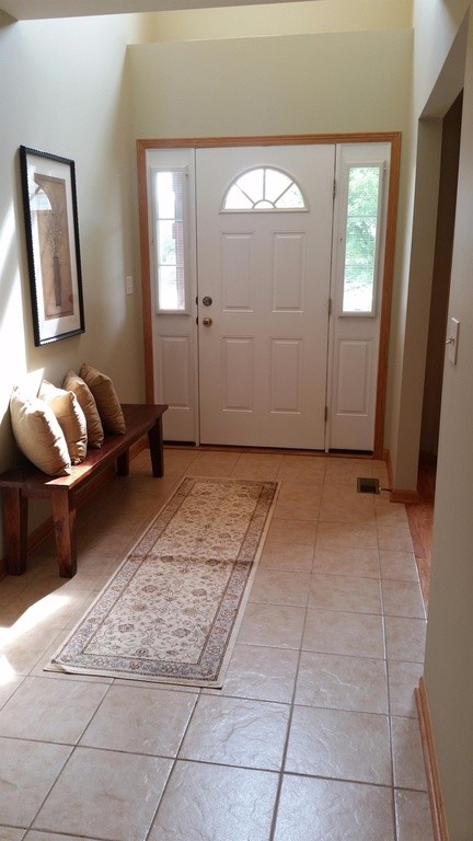 Cette photo montre une petite porte d'entrée chic avec un mur beige, un sol en carrelage de céramique, une porte simple, une porte blanche et un sol beige.