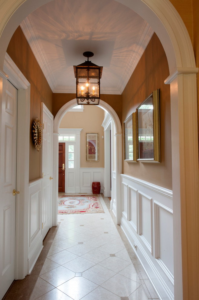 他の地域にあるお手頃価格の広いエクレクティックスタイルのおしゃれな玄関ロビー (茶色い壁、無垢フローリング、白いドア) の写真