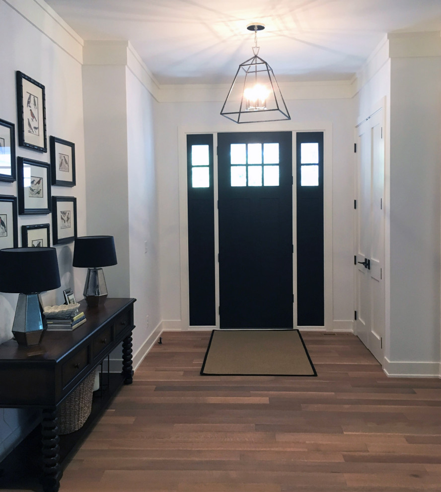 Example of a mid-sized country light wood floor and brown floor entryway design in Minneapolis with gray walls and a black front door