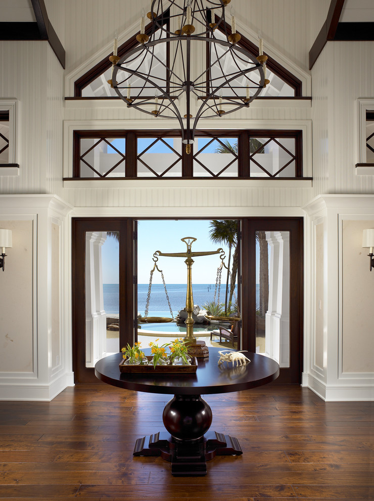This is an example of a large eclectic foyer in Miami with white walls, dark hardwood flooring and a double front door.