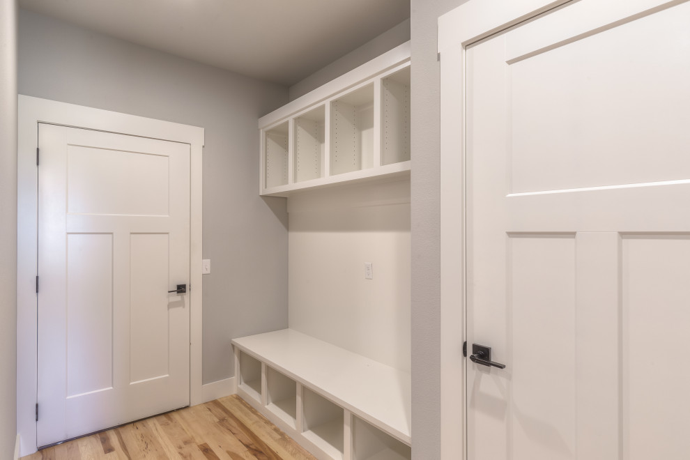Medium sized traditional boot room in Other with grey walls, medium hardwood flooring, a single front door, a white front door and brown floors.