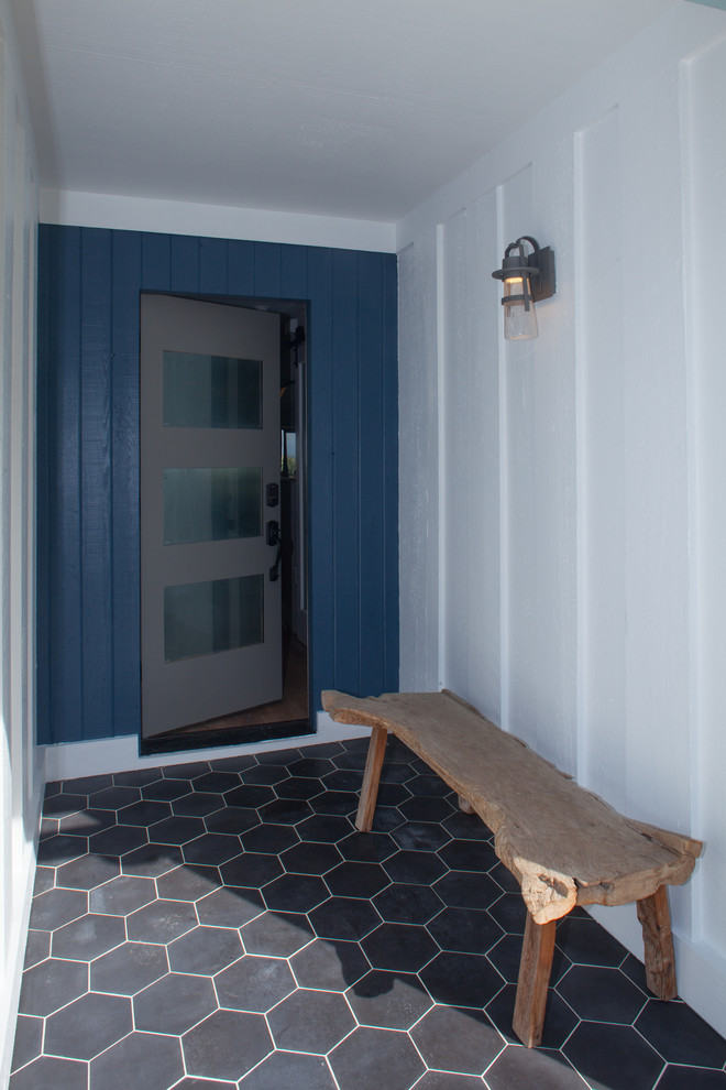 Maritim inredning av en mellanstor foajé, med vita väggar, klinkergolv i porslin, en enkeldörr, en grå dörr och grått golv