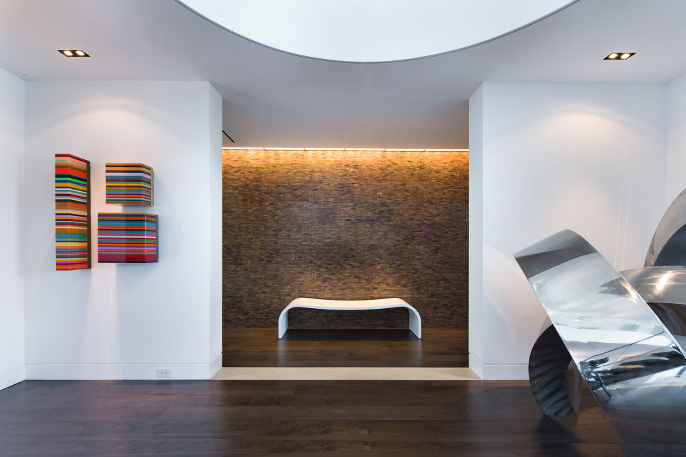 Modernes Foyer mit weißer Wandfarbe, dunklem Holzboden, braunem Boden und Holzwänden in Miami