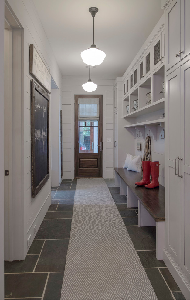 На фото: прихожая со шкафом для обуви в классическом стиле с белыми стенами, одностворчатой входной дверью, входной дверью из темного дерева и серым полом