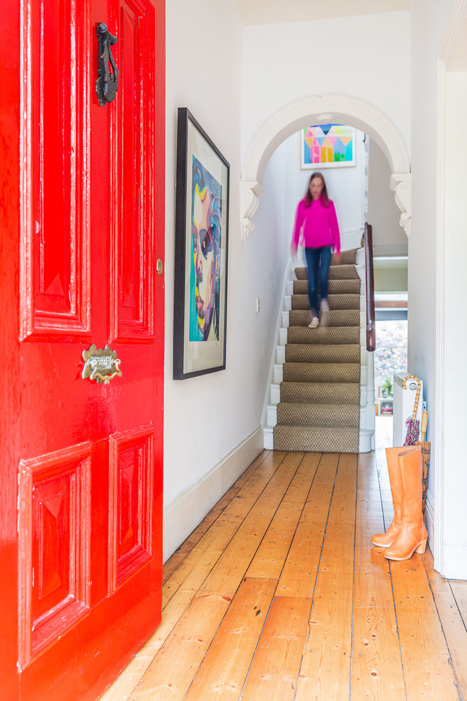 メルボルンにあるエクレクティックスタイルのおしゃれな玄関ドア (赤いドア、白い壁、淡色無垢フローリング) の写真