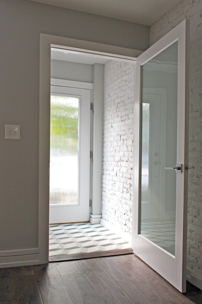 Imagen de vestíbulo contemporáneo pequeño con paredes grises, suelo de cemento, puerta simple y puerta blanca