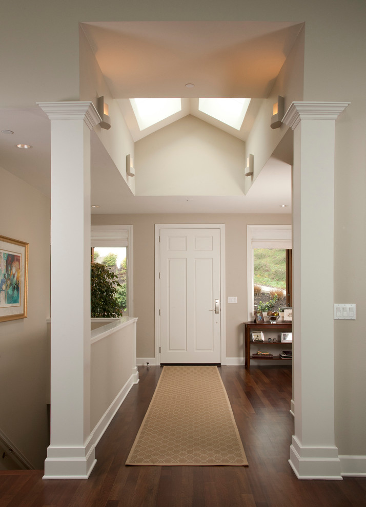 Example of a large classic dark wood floor entryway design in Seattle with beige walls and a white front door