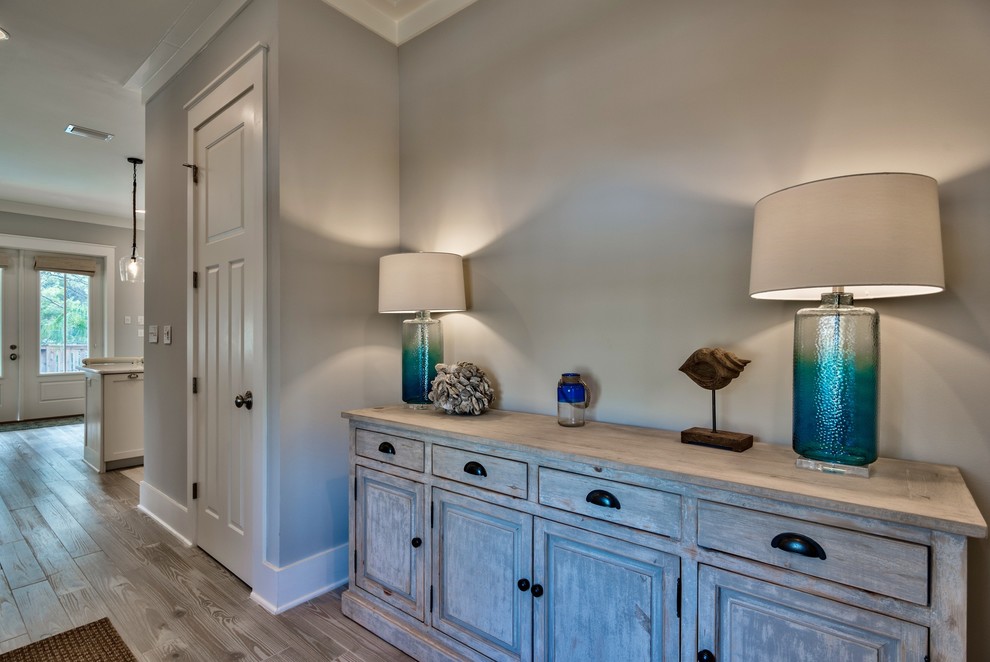 Example of a small beach style light wood floor entry hall design in Miami with gray walls