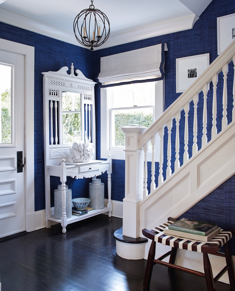 Exemple d'un hall d'entrée bord de mer avec un mur bleu, parquet foncé, une porte simple et une porte blanche.