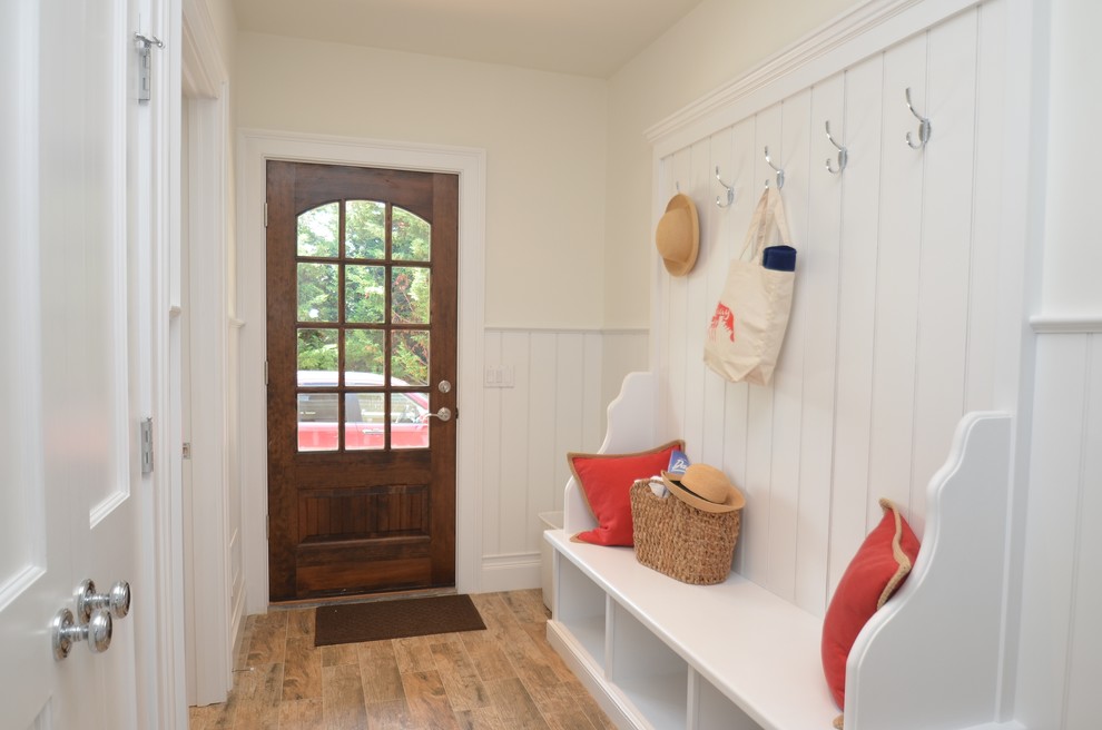 Photo of a beach style boot room in New York with a single front door and a dark wood front door.