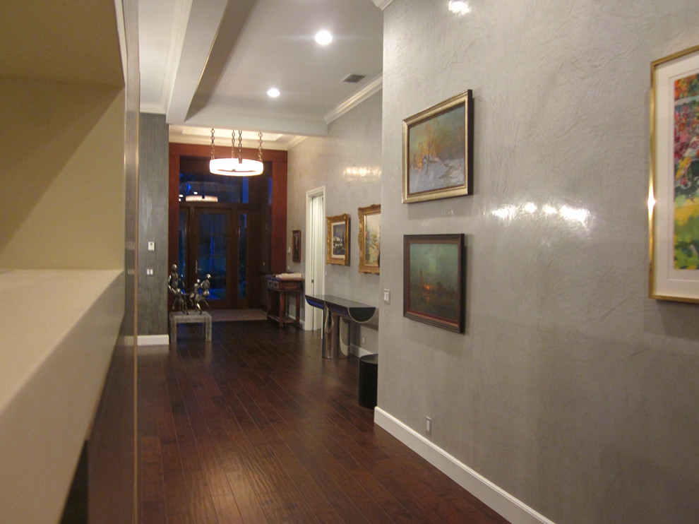 Foto di un ampio corridoio minimal con pareti grigie, parquet scuro, una porta singola e una porta in legno scuro