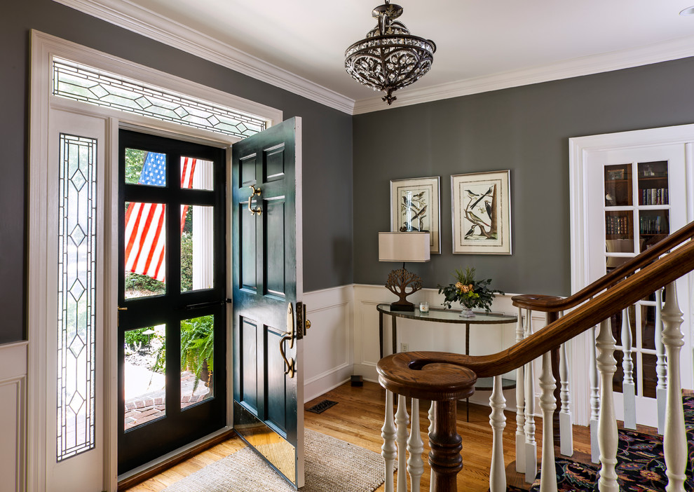 Klassische Haustür mit grauer Wandfarbe, braunem Holzboden und Einzeltür in Charlotte