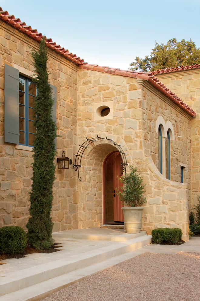 Tuscan entryway photo in Austin with a medium wood front door