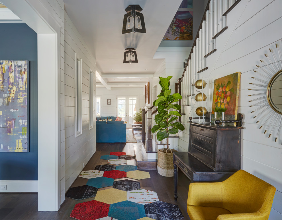 Photo of a farmhouse hallway in Houston with white walls, dark hardwood flooring and brown floors.