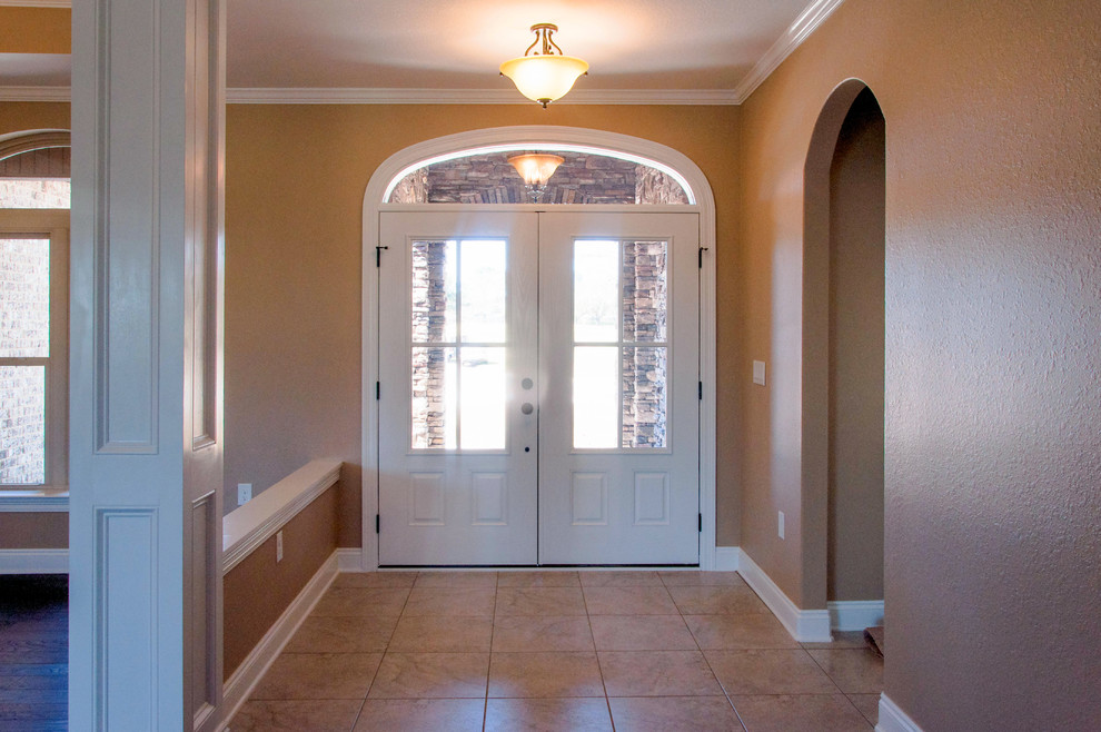 Immagine di una porta d'ingresso classica di medie dimensioni con pareti beige, pavimento con piastrelle in ceramica, una porta a due ante e una porta bianca