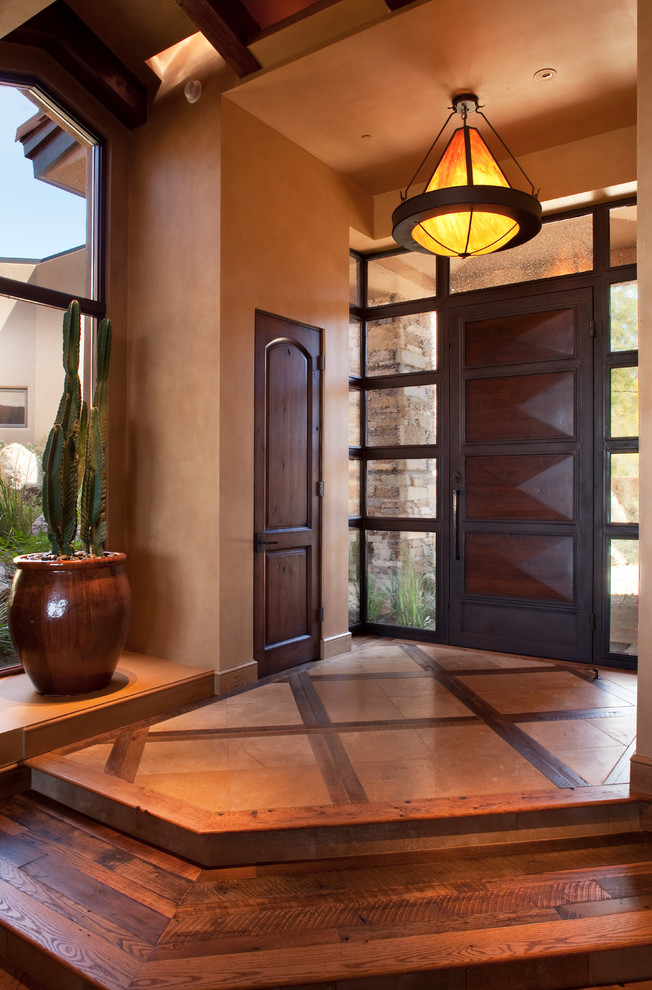 Exemple d'une grande porte d'entrée tendance avec un mur beige, une porte simple, une porte en bois foncé, parquet foncé et un sol beige.