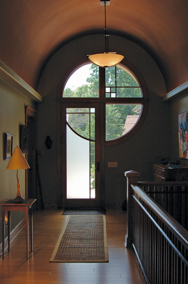 Ejemplo de puerta principal de estilo americano de tamaño medio con paredes grises, suelo de madera en tonos medios, puerta simple y puerta de vidrio