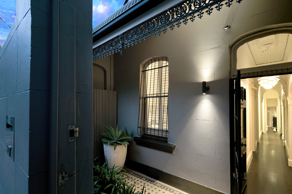 Immagine di una porta d'ingresso classica con una porta singola, una porta nera, pareti grigie, parquet scuro e pavimento nero