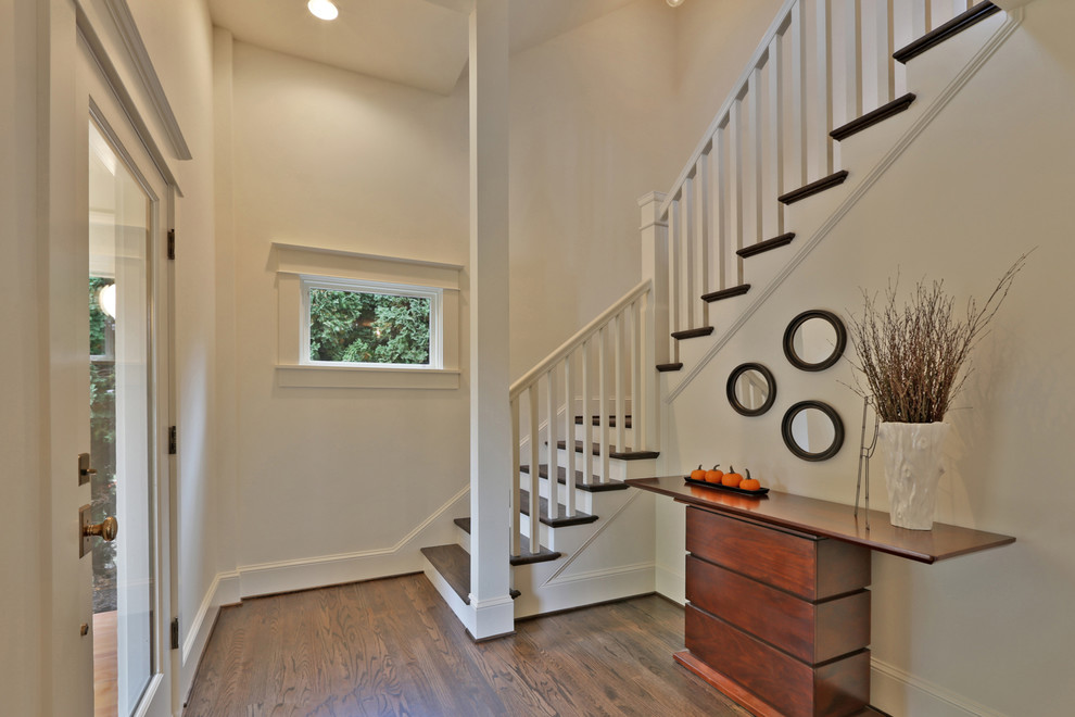Entryway - mid-sized transitional dark wood floor entryway idea in Portland with white walls and a black front door