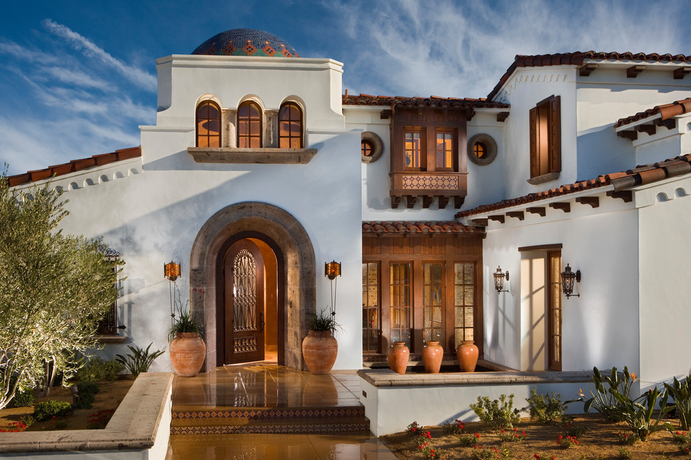 Mediterrane Haustür mit weißer Wandfarbe, Einzeltür, hellbrauner Holzhaustür, gelbem Boden und Betonboden in Orange County