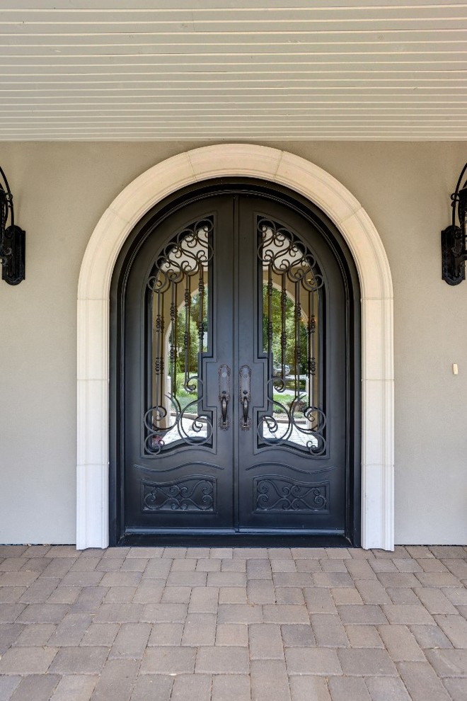Imagen de puerta principal tradicional grande con paredes beige, puerta doble y puerta metalizada