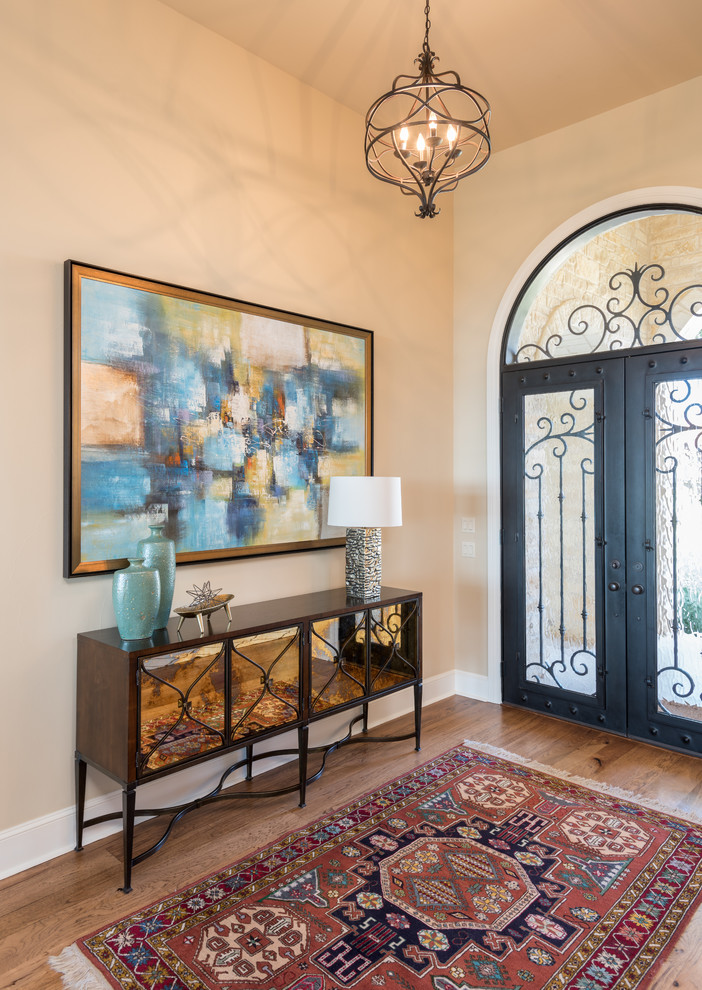 Mediterranes Foyer mit beiger Wandfarbe, Doppeltür, braunem Holzboden und Haustür aus Glas in Austin