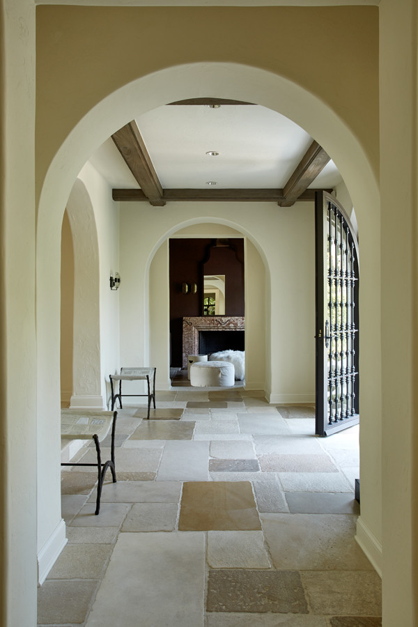 Cette image montre un hall d'entrée minimaliste de taille moyenne avec un mur beige, tomettes au sol, une porte simple et une porte marron.