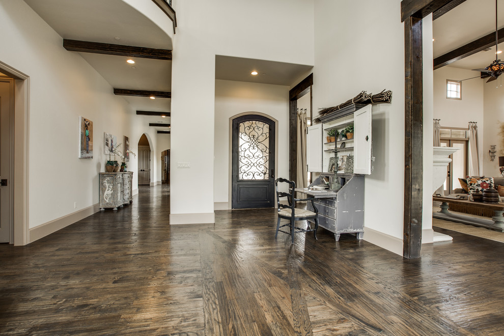 Geräumiges Mediterranes Foyer mit beiger Wandfarbe, braunem Holzboden, Einzeltür und Haustür aus Metall in Dallas