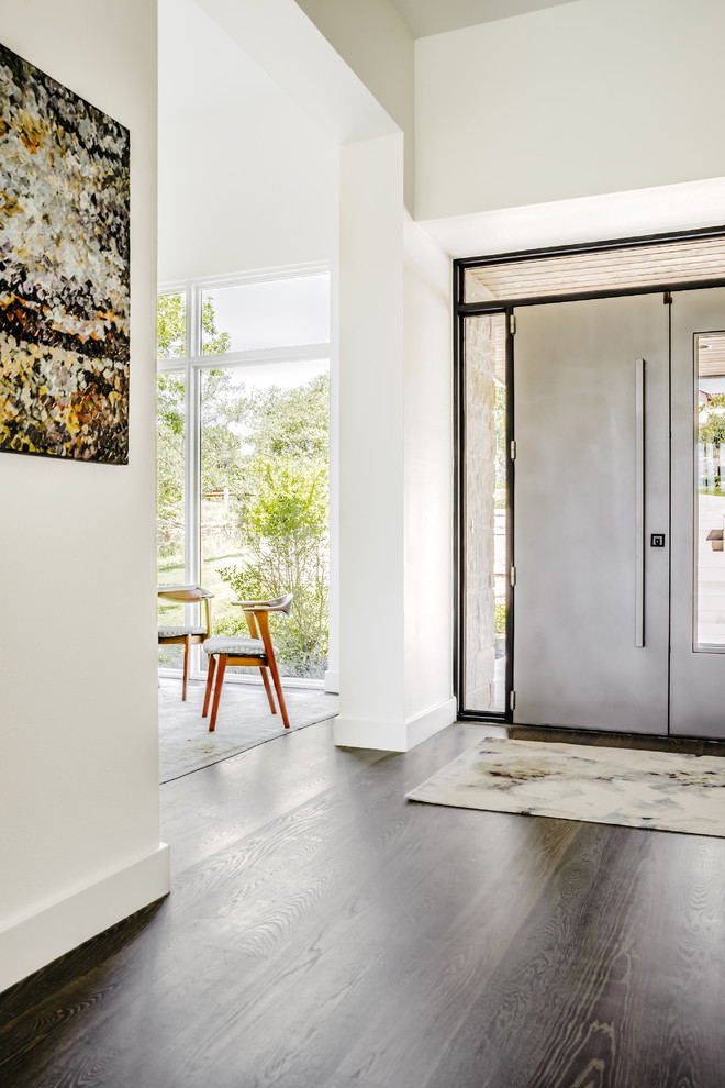 На фото: фойе среднего размера в современном стиле с белыми стенами, светлым паркетным полом, двустворчатой входной дверью, металлической входной дверью и серым полом с